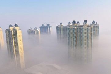 منازل ومبان تظهر وسط الضباب في إحدى المناطق في الصين
