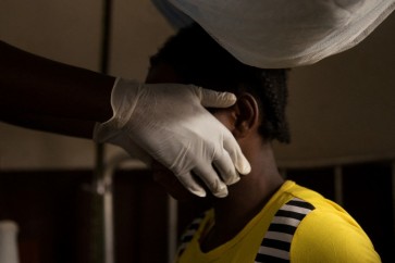 A doctor examines a woman infected with monkeypox at a quarantine area of the centre of the International medical NGO Doctors Without Borders (Medecins sans frontieres - MSF), in Zomea Kaka, in the Lobaya region, in the Central African Republic on October 18, 2018. - Monkeypox is a contagious disease, without remedy, which heals itself, but who can kill if not treated in time. Since May 2018, the monkeypox virus, which spreads in tropical Africa, has become a "public health threat" in the Central African Republic, according to the Pasteur Institute of Bangui. (Photo by CHARLES BOUESSEL / AFP)